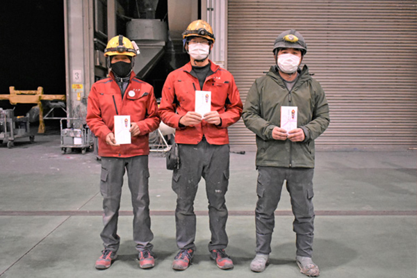 お祝いを手に並ぶ３人